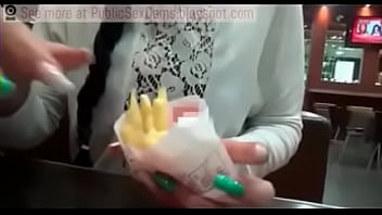 Une fille mange une éjaculation publique sur des frites