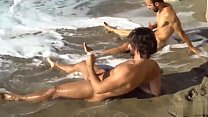 Dois amigos gays se acariciando na praia