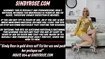 Sindy Rose con un vestido dorado se golpea el culo con un puño y le saca el prolapso