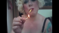 A Blonde Retro Mistress Smoking A Yellow Sobranie Cigarette With Match Light Up