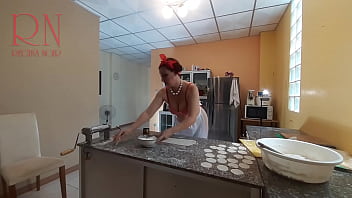 A governanta nudista Regina Noir cozinhando na cozinha. A empregada nua faz bolinhos. Cozinheiros nus.